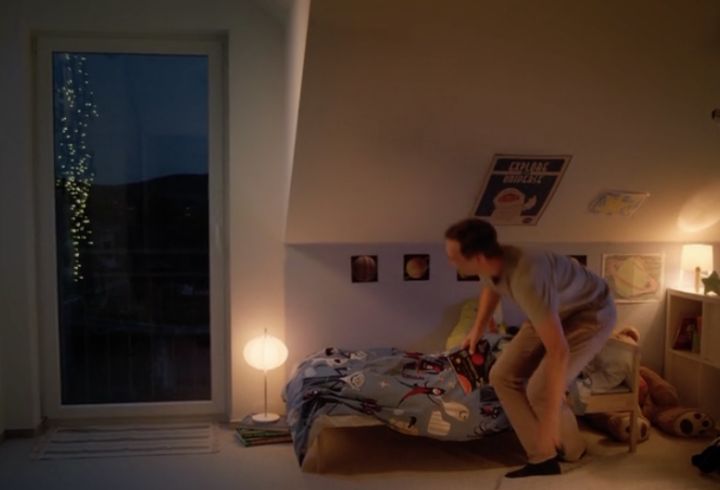 Kinderzimmer bei Abendlicht mit bodentiefem Fenster und eingesetztem Spannrahmen; ruhige Atmosphäre, sichere Lüftung ohne Insekten, Kind bereitet sich aufs Schlafen vor.