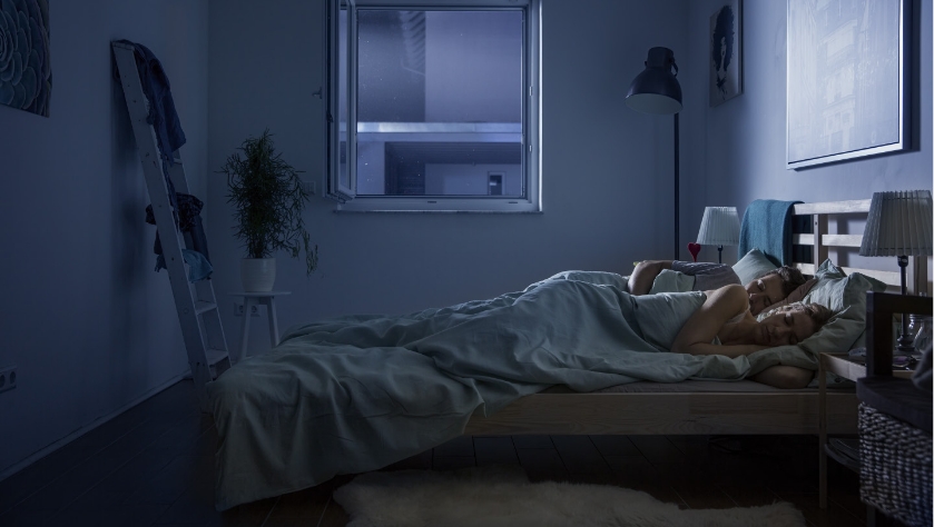 Schlafzimmer bei Nacht: Paar schläft entspannt bei geöffnetem Fenster mit Neher Polltec Insektenschutz.