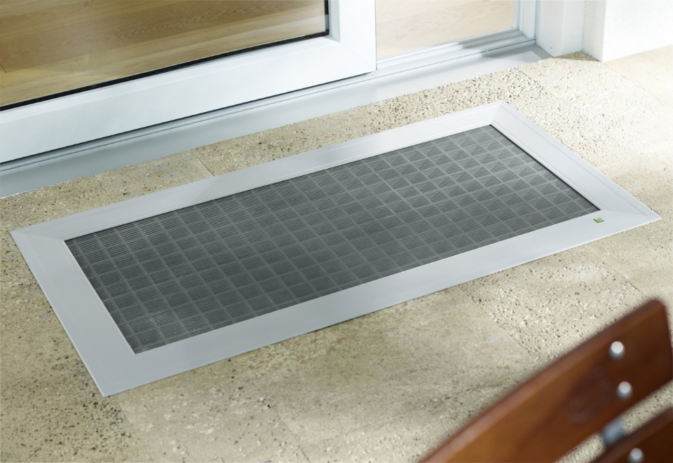 ELSA Einleger‑Lichtschachtabdeckung mit umlaufendem Aluminiumrahmen bündig in einen Steinbelag vor der Terrassentür eingesetzt.