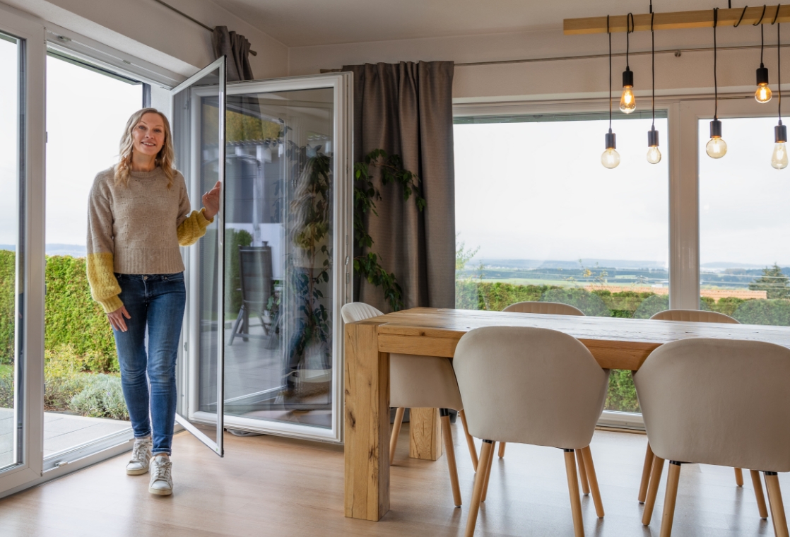 Person bedient Pendeltür und schwenkt die Tür nach innen in den Wohnraum.