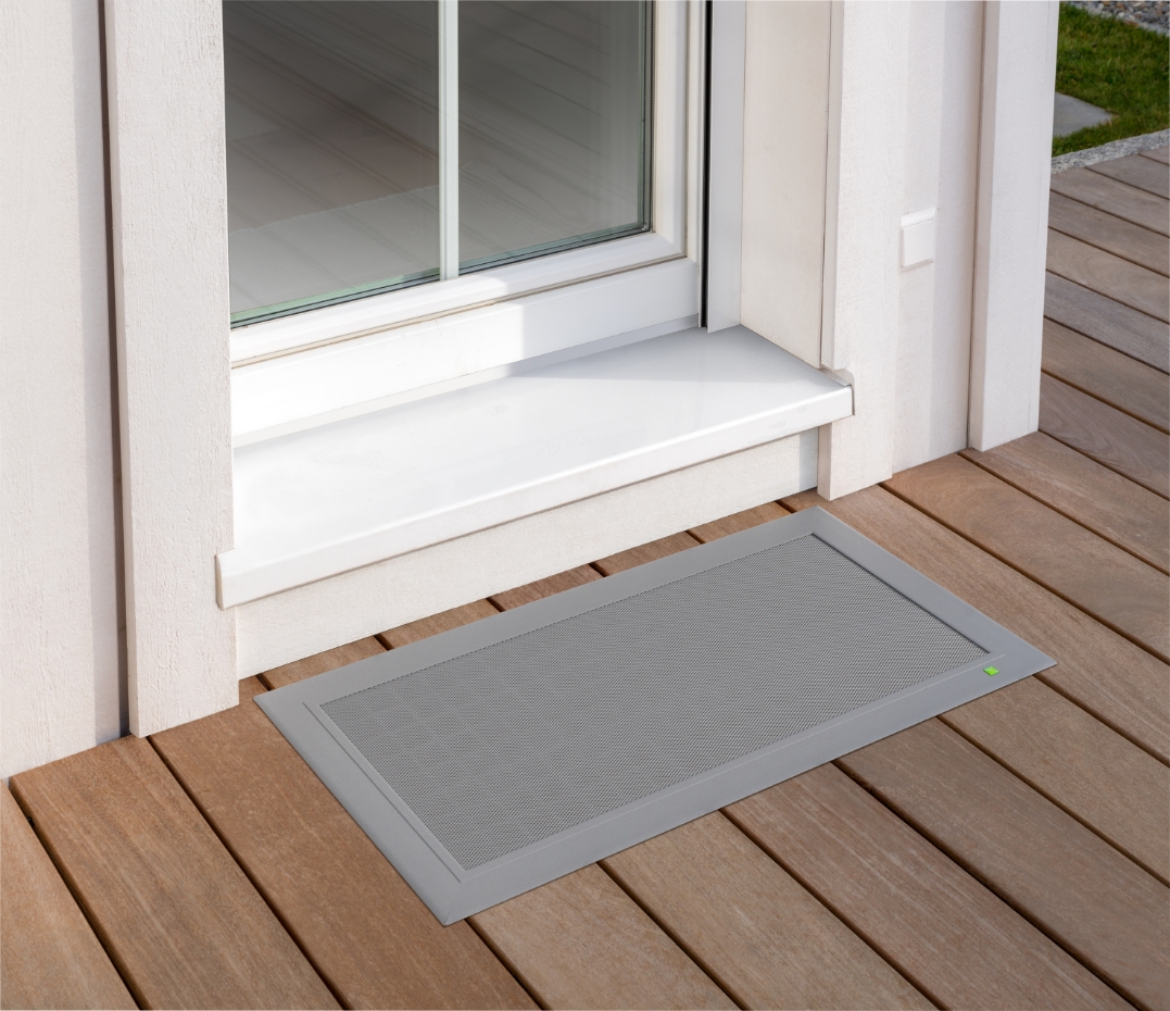 TERRESA Lichtschachtabdeckung mit schlankem Rahmen, bündig in die Holzterrasse integriert und jederzeit trittsicher zugänglich.