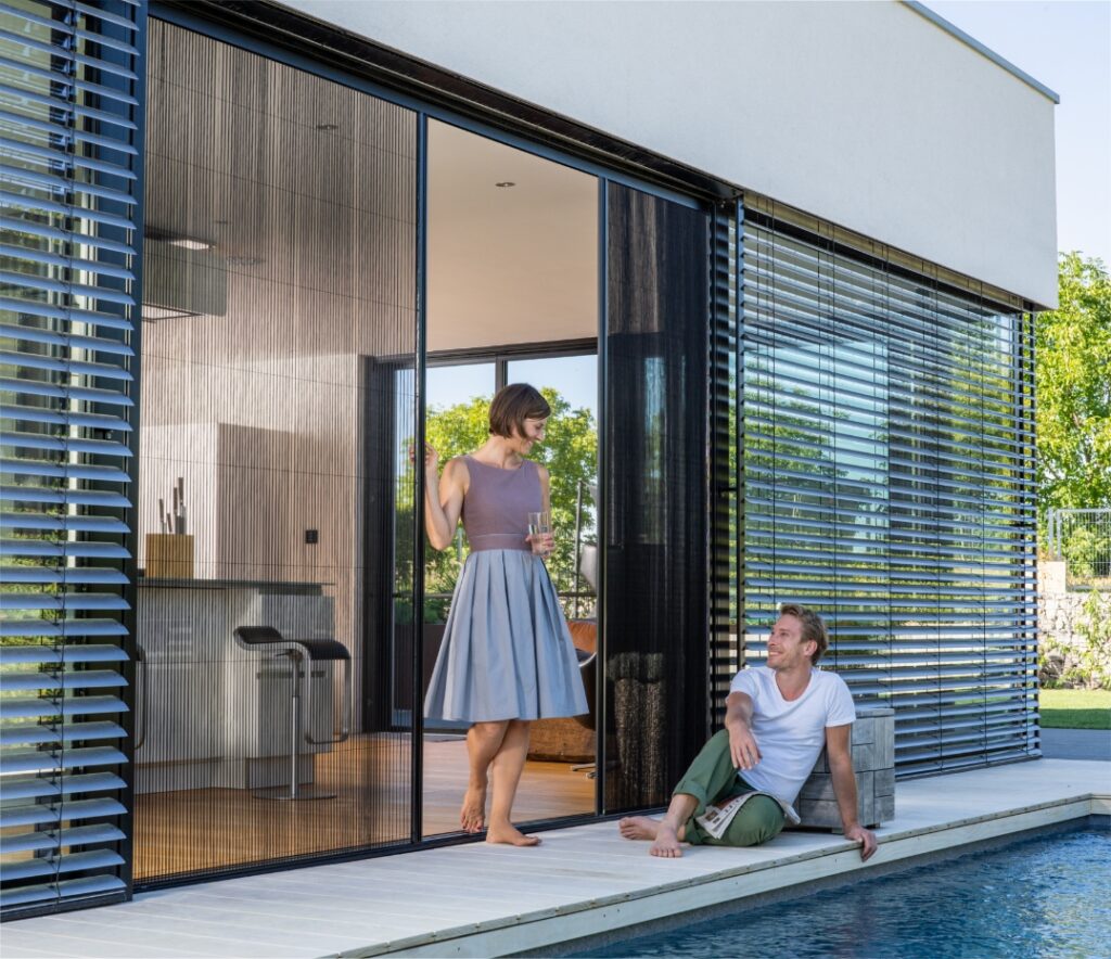 Zweiflügeliges Neher Insektenschutz-Plissee an der Terrassentür; beide Flügel lassen sich unabhängig verschieben, feine Faltenstruktur, barrierearmer Durchgang.