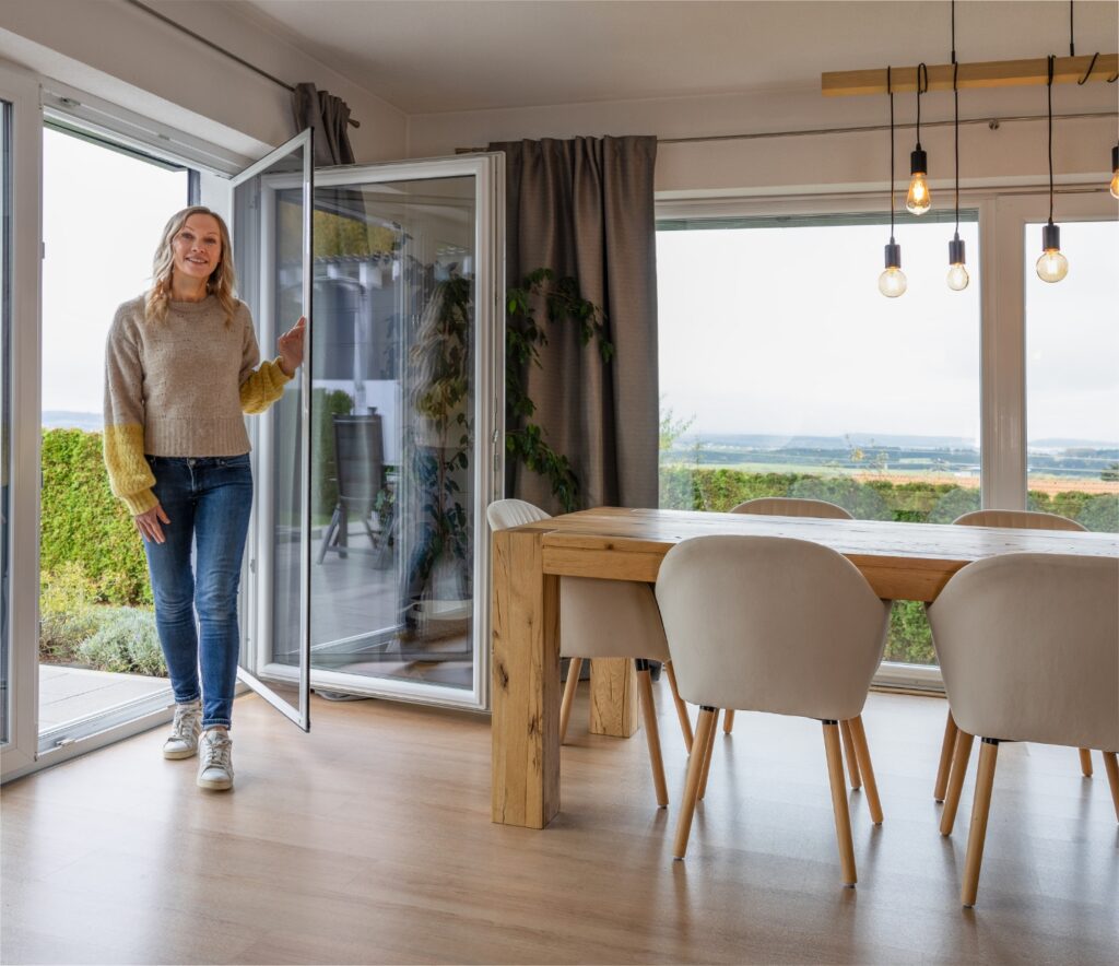Neher Insektenschutz-Pendeltür am Terrasseneingang; Türflügel pendelt beidseitig, schlanke Aluminiumprofile, transparentes Gewebe für freie Sicht.