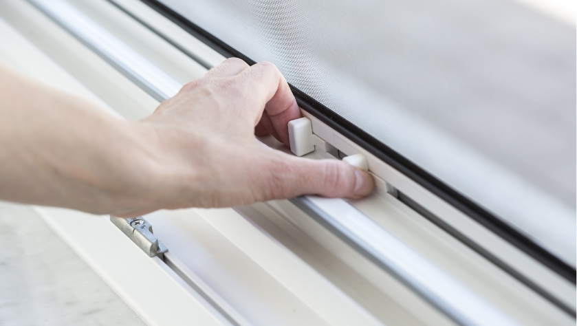 Nahaufnahme der Bedienung eines Insektenschutz-Rollos mit einem praktischen und einfachen Griffmechanismus.