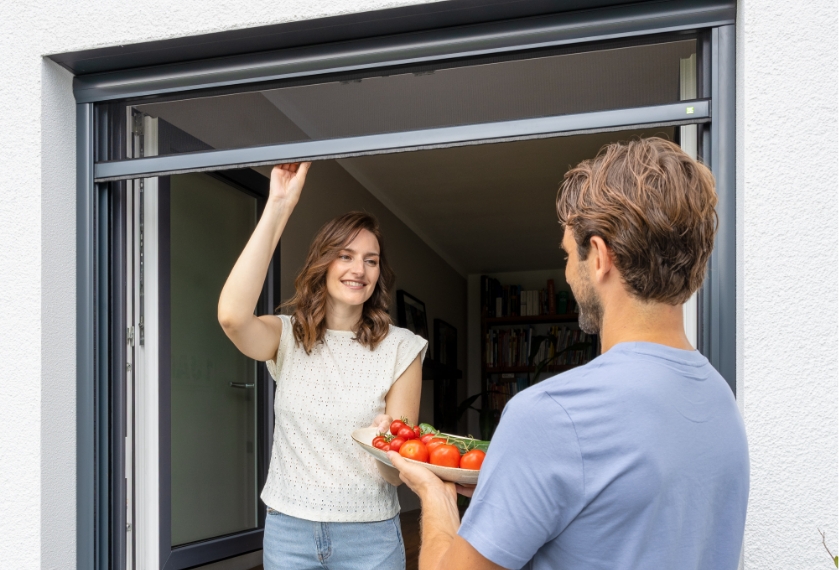 Neher Insektenschutzrollo am Fenster, leichte Bedienung mit einer Hand. Geeignet als Durchreiche zum Garten.