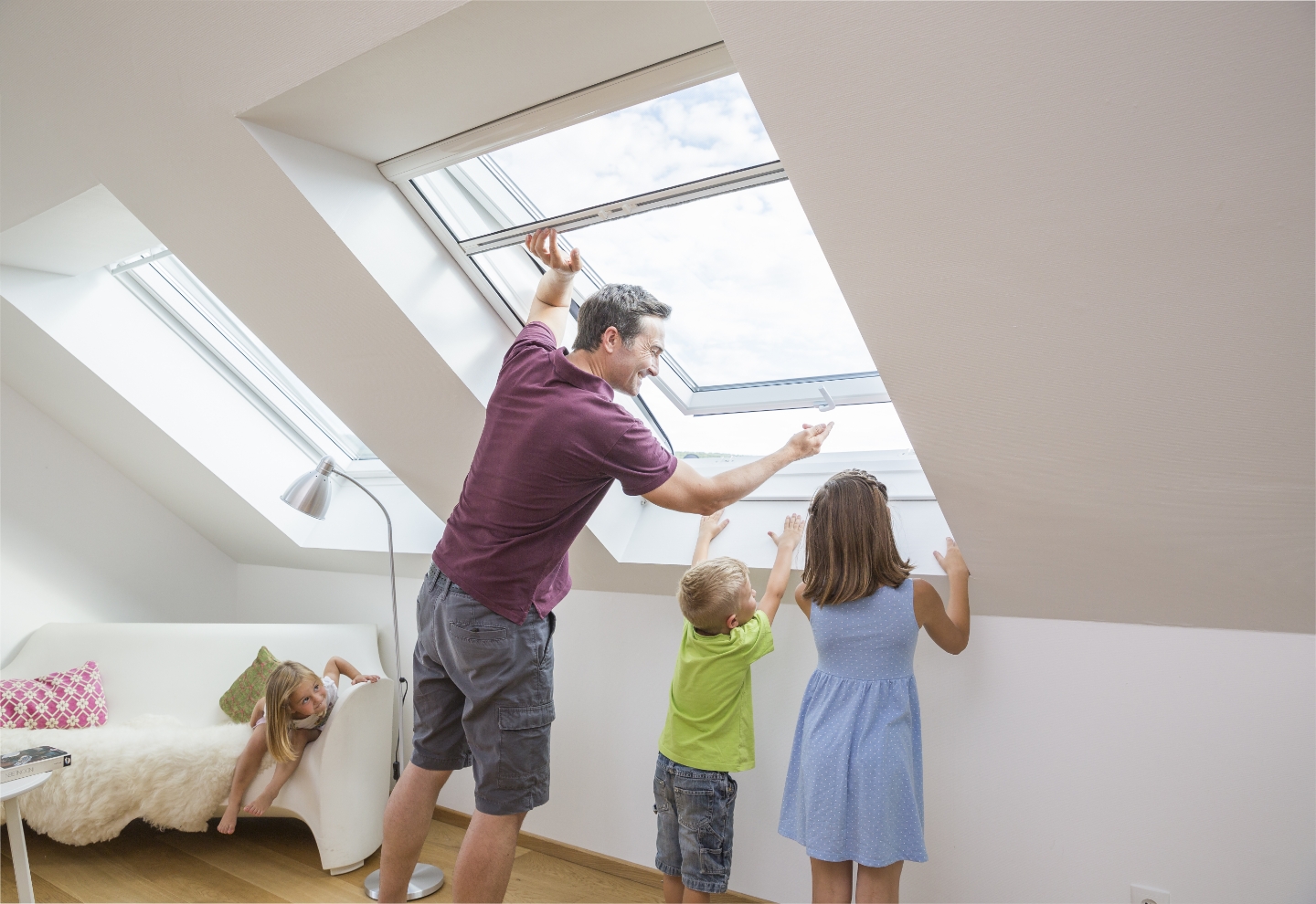 Vater zeigt Kindern, wie ein Fliegengitter-Rollo funktioniert, und hält einen Marienkäfer am Finger aus dem Fenster.