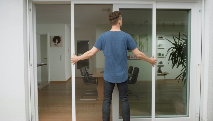 Person hängt eine Neher Schiebeanlage an der Terrassentür aus und erneut ein.